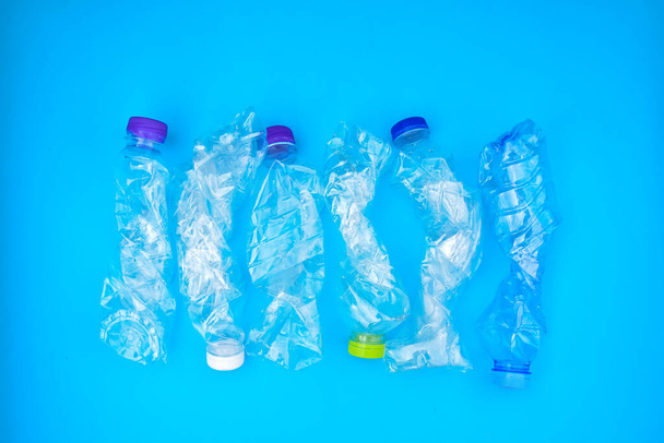 Empty plastic bottles and twisted plastic bottled in handd, concept for reducing global warming, pollution and save the environment aroud the world. - Photo, Image