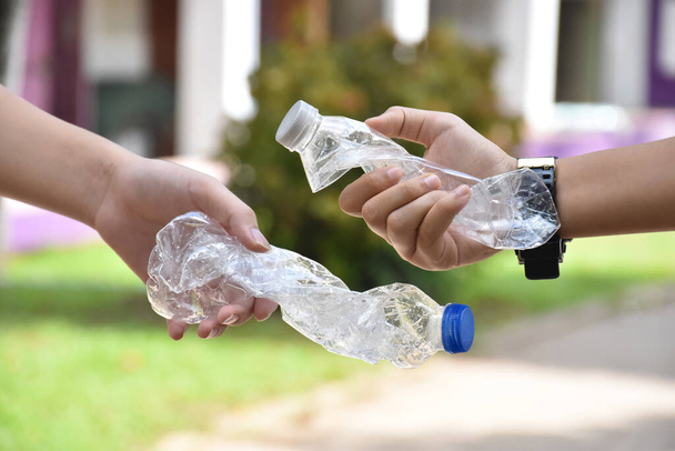 Пустые пластиковые бутылки и крученый пластик бутылки в руке, концепция для снижения глобального потепления, загрязнения окружающей среды и сохранить окружающую среду во всем мире. - Фото, изображение