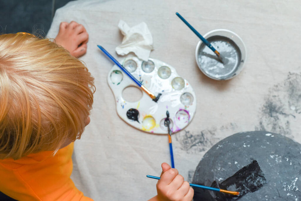Dziecko robi sztukę i rzemiosło chłopiec maluje swój projekt w domu - Zdjęcie, obraz