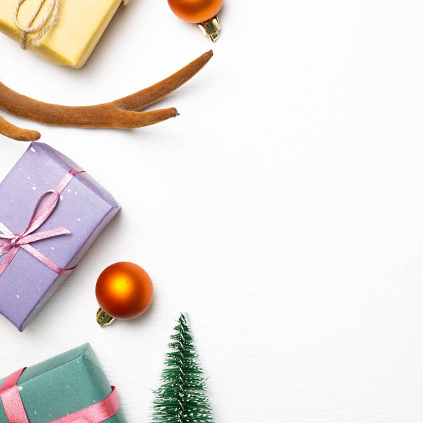 Weihnachtskonzept. Geschenkschachteln mit Tanne, glänzende Kugeln auf weißem Hintergrund. flache Lage, Draufsicht, Kopierraum - Foto, Bild
