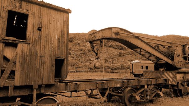Un vagón oxidado y abandonado fuera del ferrocarril. El vagón podrido se encuentra en un bosque tropical (colores Sepia) - Foto, Imagen