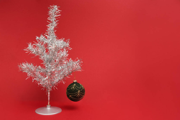 Photograph of a retro tinsel Christmas tree on a red background  - Photo, Image
