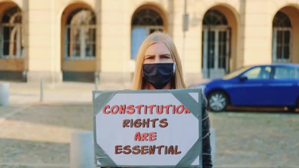 Caminata de protesta: mujer enmascarada abogando por la protección de los derechos constitucionales - Imágenes, Vídeo