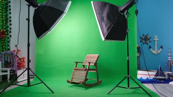 Фото или видео студия с двумя гексагоновыми огнями студии. Зеленый экран и кресло-качалка - Кадры, видео