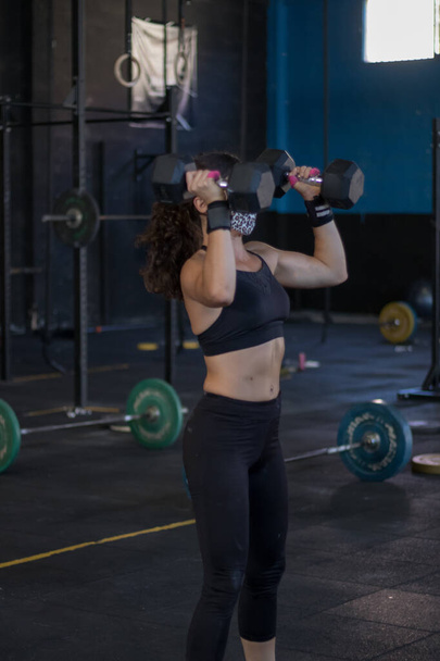 girl with mask in a gym doing cross training - Foto, imagen