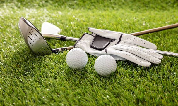 Golfuitrusting, stokken, handschoen en golfballen op groene baan gazon, close-up uitzicht, banner. Golfsport en clubconcept - Foto, afbeelding