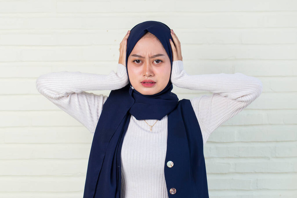  moslim jong aziatisch vrouw een bedekt haar oren. - Foto, afbeelding