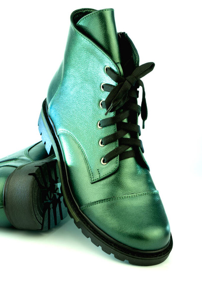 Green leather shoes. Winter and autumn off-season boots. Stylish boot isolated on white background. Close-up. Laces, tractor sole, comfortable last. Casual style. Copy space. Pearlescent color. - 写真・画像