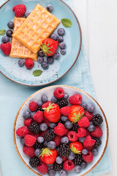 Fresh berries salad in a plate on a  wooden background. Flat lay, top view, copy space. - Foto, Imagem