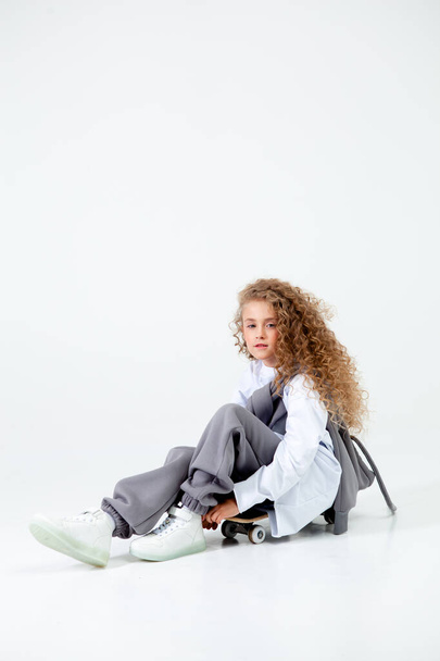 curly-haired girl in grey sportswear - Valokuva, kuva
