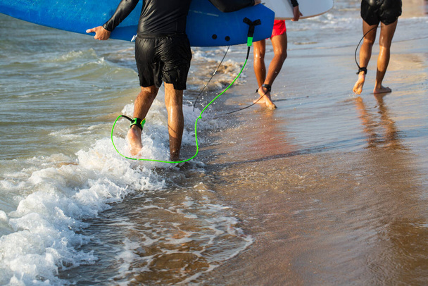 Surffaajat valmiina surffaamaan rannalla. Kesäaika ja aktiivinen lepo käsite. - Valokuva, kuva