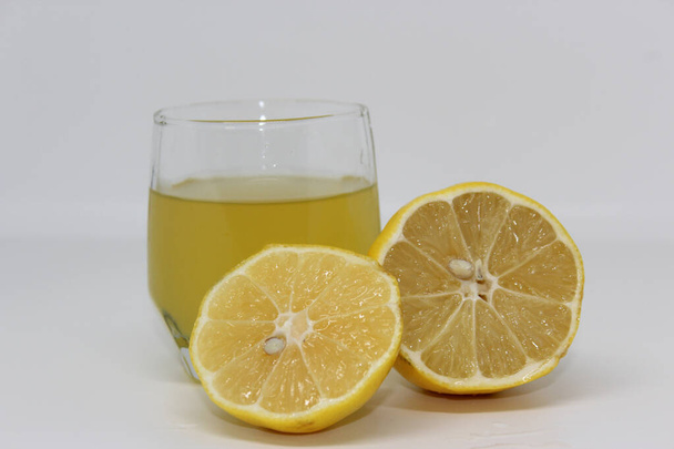 Λεμόνι και χυμό λεμονιού στο ποτήρι - Φωτογραφία, εικόνα