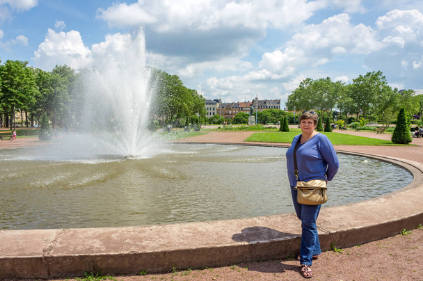 Ώριμη παχουλή γυναίκα με γυαλιά ξεκουράζεται σε ένα πάρκο της πόλης - Φωτογραφία, εικόνα