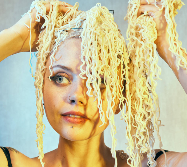 Funny hungry girl with curly noodles on her head. - Fotó, kép