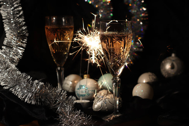 Два бокала шампанского, искры и рождественские украшения. Атмосфера праздника Боке. Не в фокусе. С Новым годом и Рождеством!! - Фото, изображение