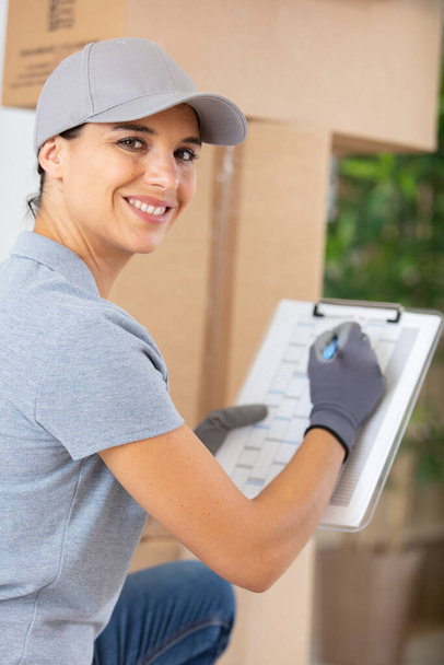 portrait of female delivery driver with clipboard - Photo, image