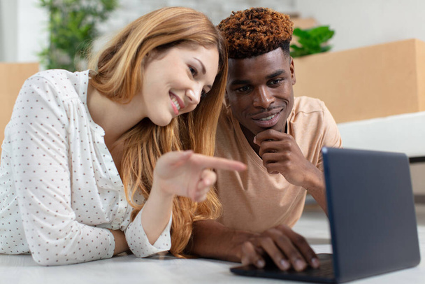 young couple using laptop computer at home - Fotó, kép