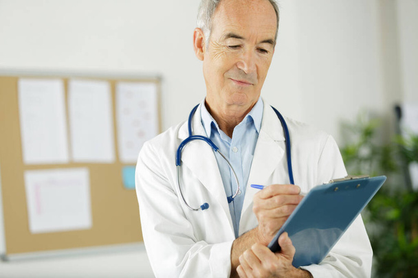 a senior doctor with clipboard - Foto, afbeelding
