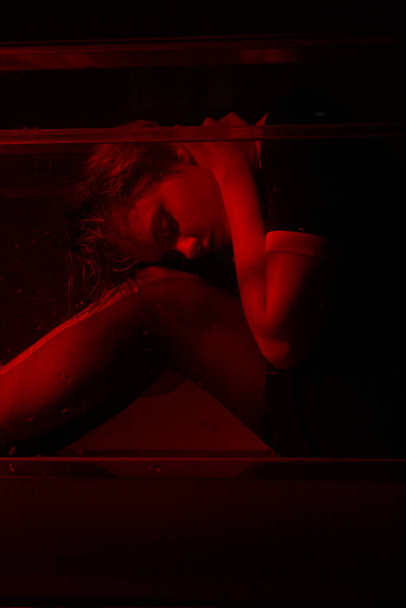 Hrozný portrét mladé dívky v hororové místnosti s červeným světlem. - Fotografie, Obrázek