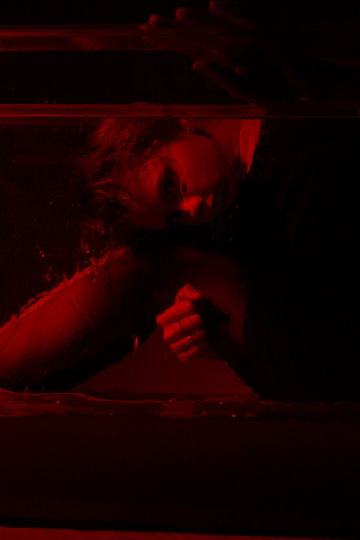 Szörnyű portré egy fiatal lányról egy horrorszobában, piros fénnyel.. - Fotó, kép