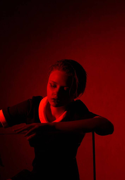 Hrozný portrét mladé dívky v hororové místnosti s červeným světlem. - Fotografie, Obrázek