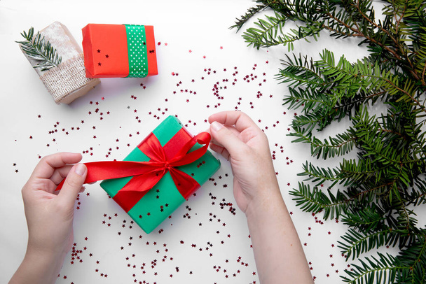 Hands hold Christmas gift with red ribbon  - Foto, afbeelding