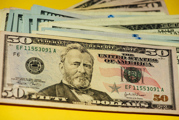 Dollars different bills. Dollars background. Background of different us dollar banknotes. Finance concept. Money on yellow background - Photo, Image