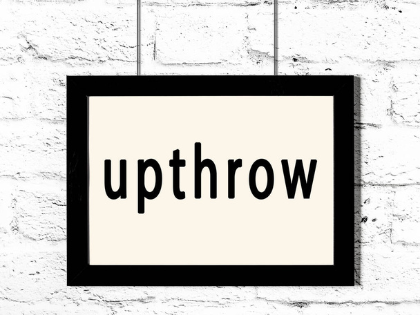 Μαύρο πλαίσιο κρέμεται σε λευκό τοίχο τούβλο με επιγραφή upthrow - Φωτογραφία, εικόνα