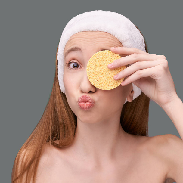 Young beauty girl remove mascara. Face sponge cleaner - 写真・画像
