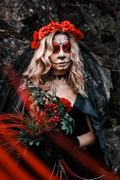 Closeup portrait of Calavera Catrina. Young woman with sugar skull makeup and red flowers. Dia de los muertos. Day of The Dead. Halloween. Santa Muerte makeup woman on Halloween eve. Fashion creative - Photo, Image