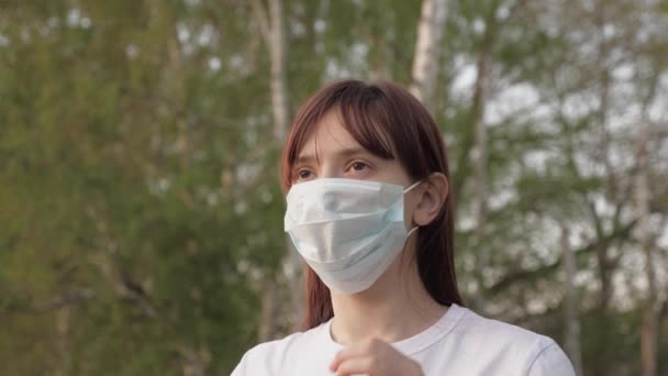 Young woman takes off medical mask. Female breathes deeply and smiling looking at camera. Health care and medical concept. Close up portrait. Life during a pandemic. Coronavirus - Footage, Video
