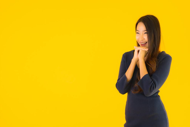 Portrait beautiful young asian woman with action on isolated yellow background - Foto, Bild