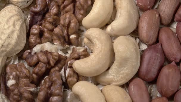 Verschiedene Nüsse auf Haferflocken aus nächster Nähe. Natürliche gesunde Ernährung. - Filmmaterial, Video