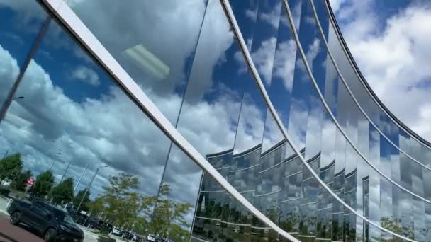 Céu ensolarado com nuvens refletidas na fachada de vidro do edifício moderno - Filmagem, Vídeo