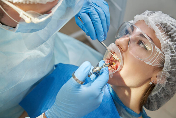 Zahnarzt, der vor der Operation eine Lokalanästhesie durchführt. Patient besucht Zahnarztpraxis - Foto, Bild