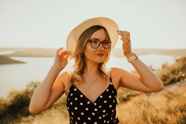 woman in a hat and glasses in the middle of meadow - Photo, Image