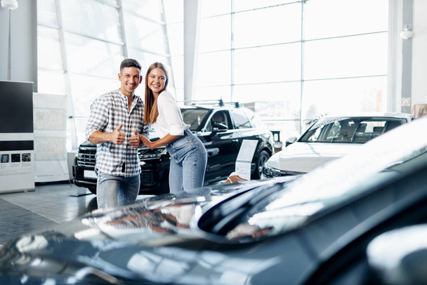 Young happy couple just bought a new car in a dealership - Photo, image