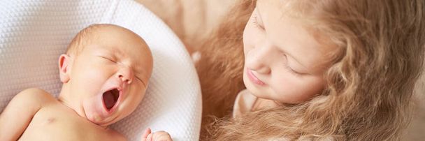 Tiny newborn. Old sister not touch little people. Healthcare massage concept - Foto, Imagem