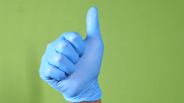 Close-up de uma mão pessoa em luvas médicas mostrando um polegar para cima. - Filmagem, Vídeo
