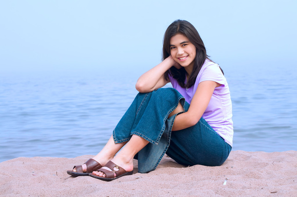 Ragazza adolescente seduta sulla spiaggia
 - Foto, immagini