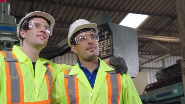 Onnelliset tehdastyöläiset hymyilevät ja seisovat yhdessä ystävän kanssa - Materiaali, video