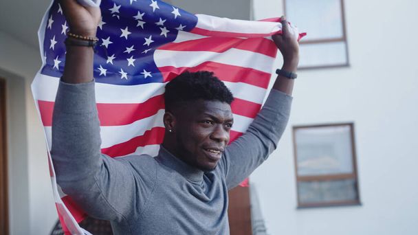 Black man african-american with USA flag on the balcony - Zdjęcie, obraz