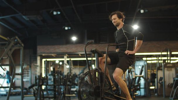 Hombre de fitness cansado haciendo ejercicio en el ejercicio en el gimnasio. Entrenamiento de hombre en el club deportivo - Foto, imagen
