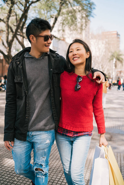 Portrait of young Asian couple in love walking in the city after shopping. Shop concept. - Foto, Imagem