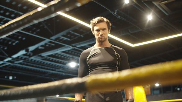 Annoyed fit man hitting fists on boxing ring. Sport man getting ready for fight - Fotoğraf, Görsel