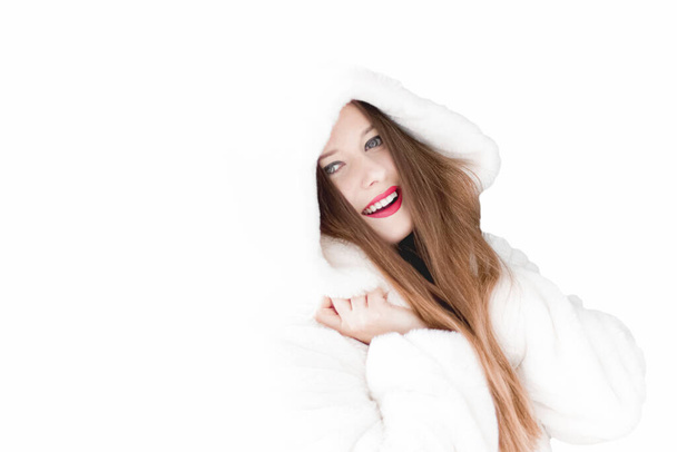 Mujer joven con abrigo de piel esponjosa con capucha, ropa de invierno cálido para la moda y las vacaciones de Navidad - Foto, imagen