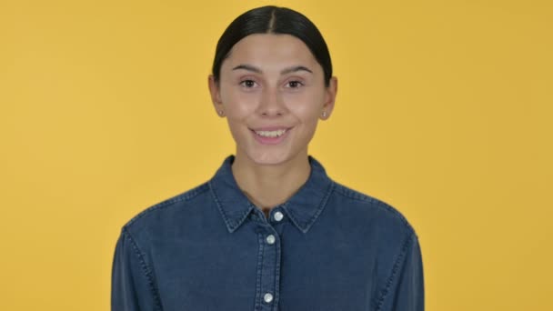Glimlachende jonge Latijnse vrouw, gele achtergrond  - Video