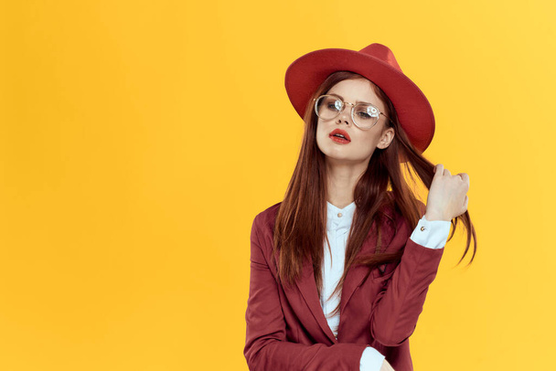 woman in red hat jacket glasses yellow background cosmetics - Fotografie, Obrázek