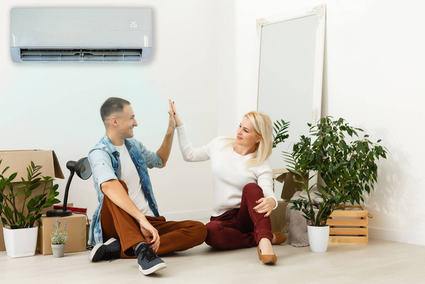 Klimaanlage im Wohnzimmer, glückliche Familie zieht in neue Wohnung - Foto, Bild