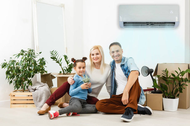 κλιματιστικό στο σαλόνι με ευτυχισμένη οικογένεια κινείται σε νέο διαμέρισμα - Φωτογραφία, εικόνα